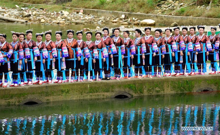 People of Dong ethnic group view performances during a harvest festival in Dongtou Village, Rongshui Miao Autonomous County, south China\'s Guangxi Zhuang Autonomous Region, Oct. 26, 2018. Local people celebrated harvest Friday through various activities like fish feast, singing and playing lusheng. (Xinhua/Huang Xiaobang)