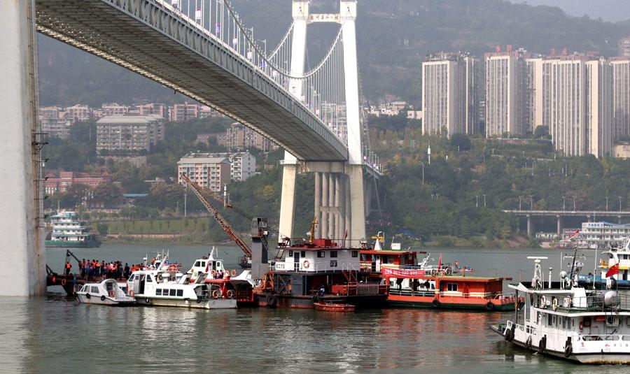 Search and rescue efforts continue after a deadly collision between a bus and a private car on Sunday. The bus careened off a bridge in Chongqing into the Yangtze River. (Photo by ZOU YI/FOR CHINA DAILY)
Authorities say more than 10 were on board; 2 bodies are recovered
At least two people died after a bus collided with an oncoming car on a Chongqing bridge and plunged into the Yangtze River on Sunday morning.
Based on inquires and footage from surveillance cameras along the route, it was estimated that the bus was carrying more than 10 passengers at the time of the crash, local authorities said in a statement.
Two bodies had been recovered from the water as of press time.
An initial investigation found that the bus abruptly swerved while on the Second Yangtze River Bridge in Chongqing\'s Wanzhou district, crossing the center of the road into oncoming traffic and slamming into a red sedan.
The bus then broke through the guardrail and plunged into the river.