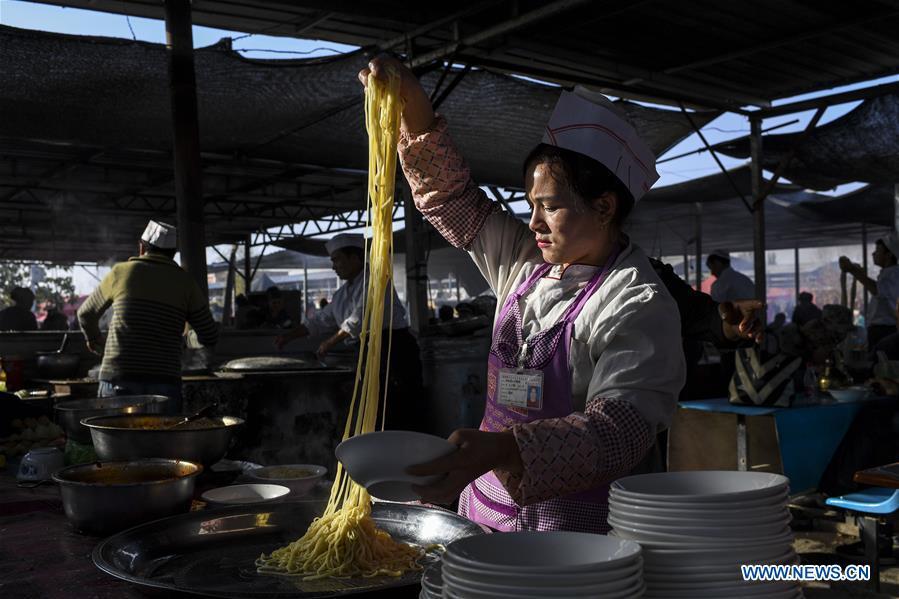 A vender makes noodles at a Sunday bazaar in Bachu County, northwest China\'s Xinjiang Uygur Autonomous Region, Oct. 28, 2018. (Xinhua/Hu Huhu)