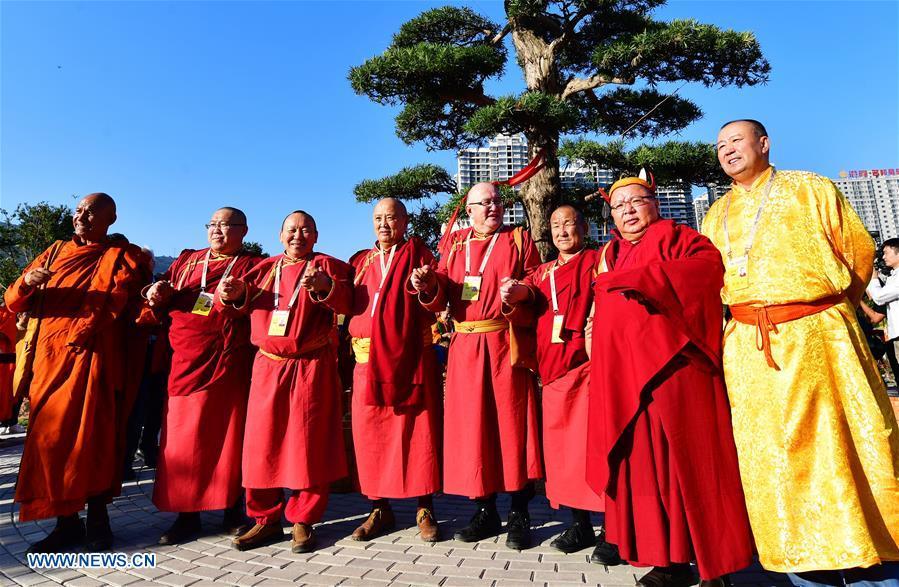 Guests for the fifth World Buddhist Forum pose for group photos during a tree planting activity in Putian, southeast China\'s Fujian Province, Oct. 28, 2018. A record number of over 1,000 Buddhists, scholars and representatives from 55 countries and regions attended the fifth World Buddhist Forum, which will last until Oct. 30.(Xinhua/Wei Peiquan)
