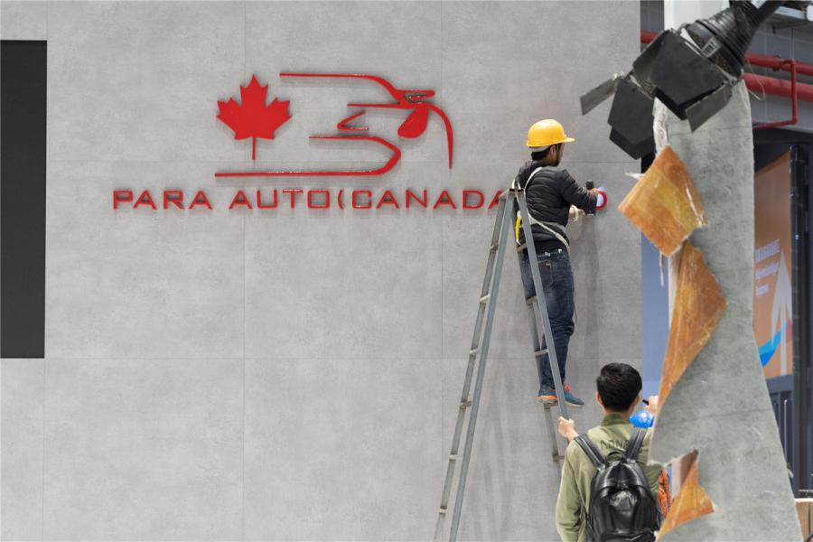 People work on the exhibition stand of Canadian company Para Auto (Canada) Ltd.  (Photo/chinadaily.com.cn)