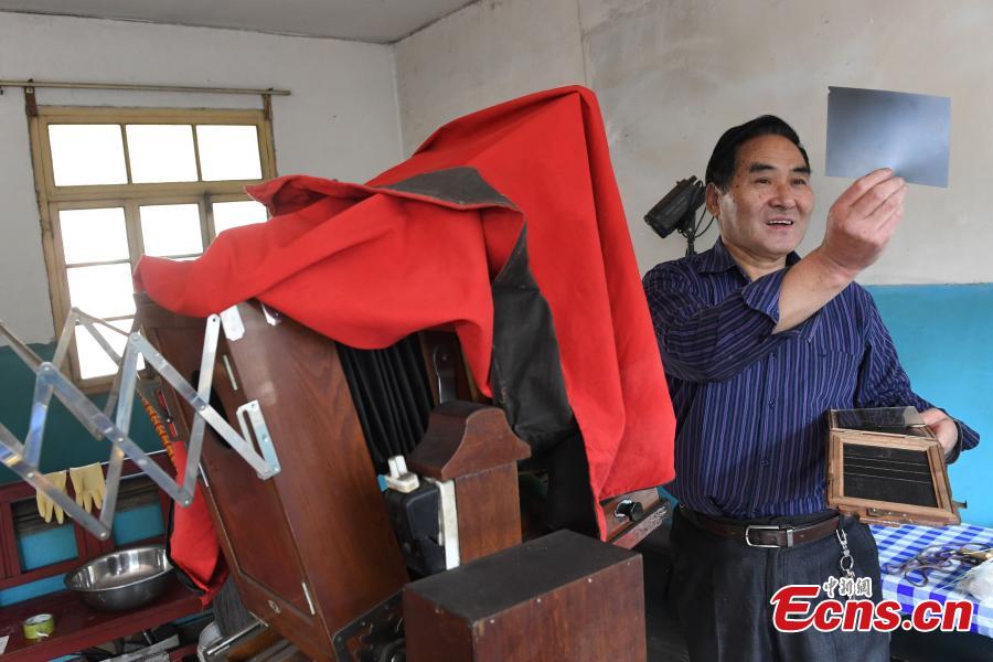Photographer Wei Jixiong takes photos with an old-fashioned film camera at the Agan Photo Studio in Lanzhou City, Northwest China’s Gansu Province, Oct. 27, 2018. Since Wei began working at the studio in the 1970s, he has continually used film cameras to take photos for customers despite the popularity of digital cameras. (Photo: China News Service/Yang Yanmin)