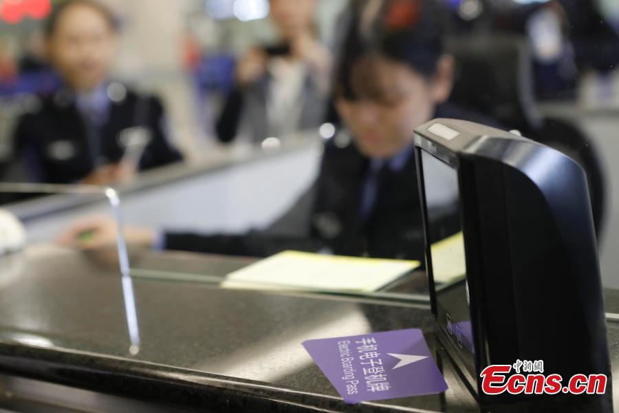 Passenger Zhang Lian, set to board a Cathay Pacific flight from Shanghai to Hong Kong, uses just a QR code to complete security and check-in procedures in approximately 10 minutes at Shanghai Pudong International Airport, Oct. 29, 2018. The airport is the first Chinese mainland airport to adopt paperless check-in for outbound passengers. (Photo: China News Service/Yin Liqin)