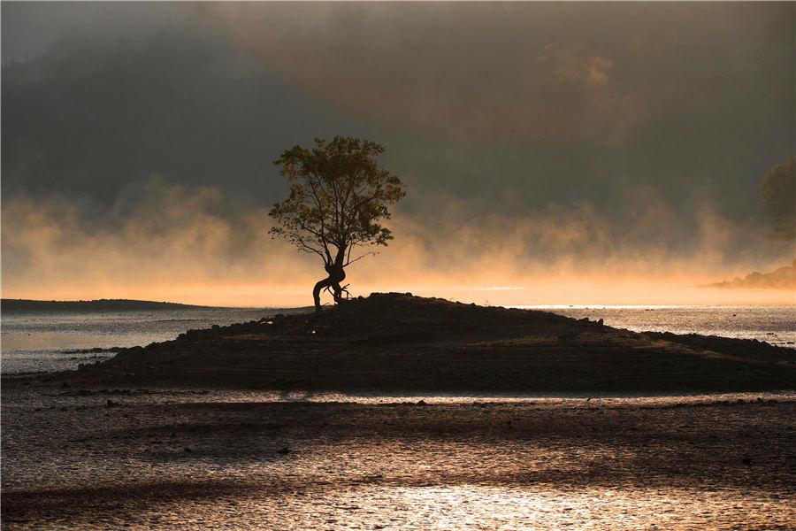 Morning mist casts a beautiful shadow above the Qishu Lake in Huangshan, East China\'s Anhui Province, Oct. 29, 2018. Located 2 kilometers from Hongcun village, a UNESCO World Cultural Heritage site, the lake offers a day tour of both natural scenery and historical gems. (Photo/Aisanewsphoto)