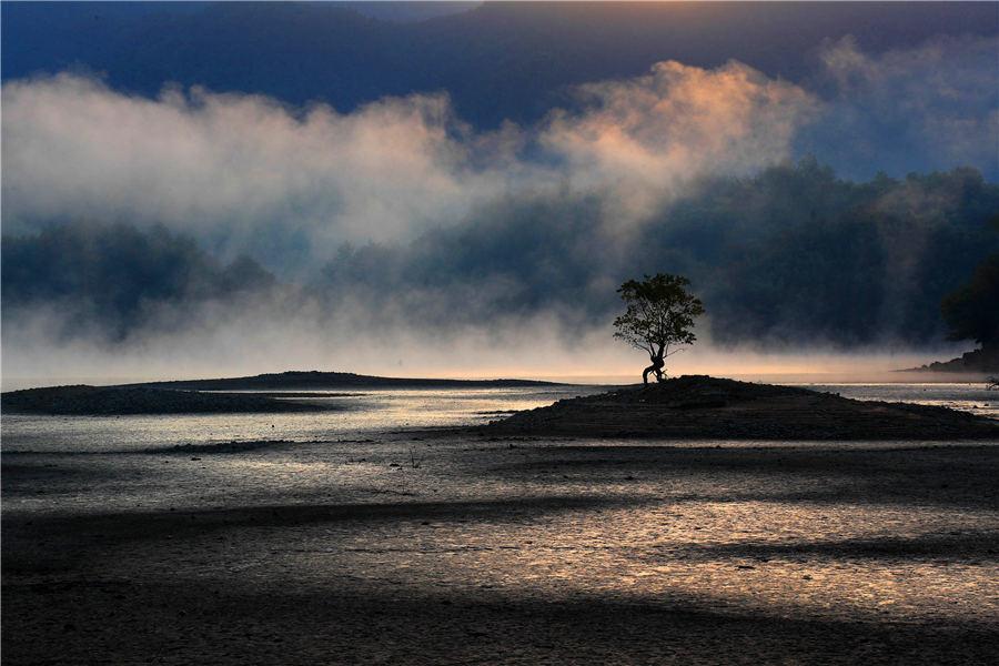 Morning mist casts a beautiful shadow above the Qishu Lake in Huangshan, East China\'s Anhui Province, Oct. 29, 2018. Located 2 kilometers from Hongcun village, a UNESCO World Cultural Heritage site, the lake offers a day tour of both natural scenery and historical gems. (Photo/Aisanewsphoto)