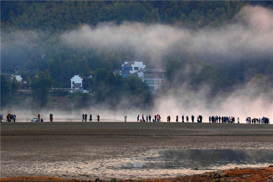 Morning mist casts a beautiful shadow above the Qishu Lake in Huangshan, East China\'s Anhui Province, Oct. 29, 2018. Located 2 kilometers from Hongcun village, a UNESCO World Cultural Heritage site, the lake offers a day tour of both natural scenery and historical gems. (Photo/Aisanewsphoto)