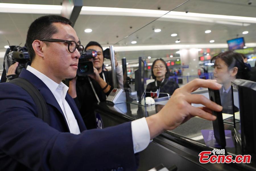 Passenger Zhang Lian, set to board a Cathay Pacific flight from Shanghai to Hong Kong, uses just a QR code to complete security and check-in procedures in approximately 10 minutes at Shanghai Pudong International Airport, Oct. 29, 2018. The airport is the first Chinese mainland airport to adopt paperless check-in for outbound passengers. (Photo: China News Service/Yin Liqin)