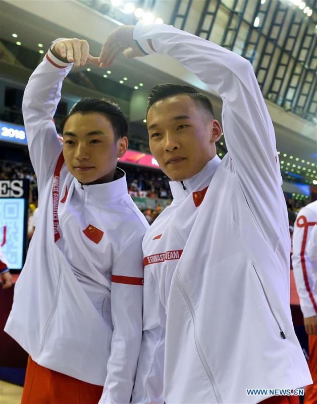 Xiao Ruoteng (R) and Zou Jingyuan of China celebrate after the Men\'s Team Final at the 2018 FIG Artistic Gymnastics Championships in Doha, capital of Qatar, Oct. 29, 2018. Team China won the gold medal. (Xinhua/Nikku)
