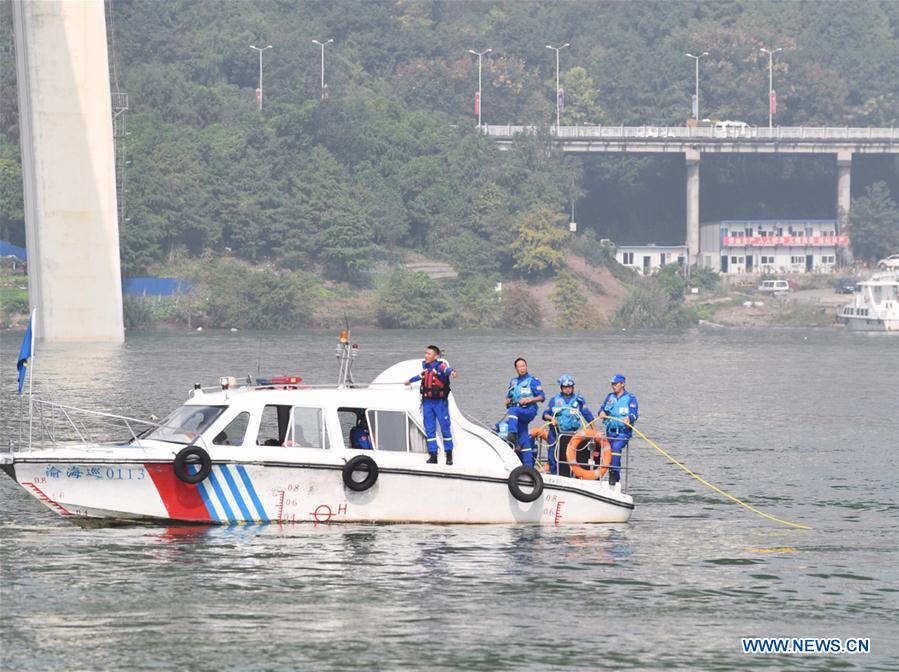 Photo taken on Oct. 29, 2018 shows rescuers working at the accident site in Wanzhou District, southwest China\'s Chongqing. Fifteen people were confirmed to have been on a bus that plunged into the Yangtze River in Chongqing on Sunday, local authorities said Monday. Two bodies have been retrieved from the river so far, but their identities are not yet known. The bus veered onto the wrong side of the road and collided into an oncoming private car before breaking through road fencing and flying off a bridge in Wanzhou District at 10:08 a.m. Sunday. Rescue work is still ongoing. With the help of a sonar system, professional rescue ships located an 11-meter-long and three-meter-wide object on the river bottom and it was believed that it is the sunken bus. (Xinhua/Wang Quanchao)