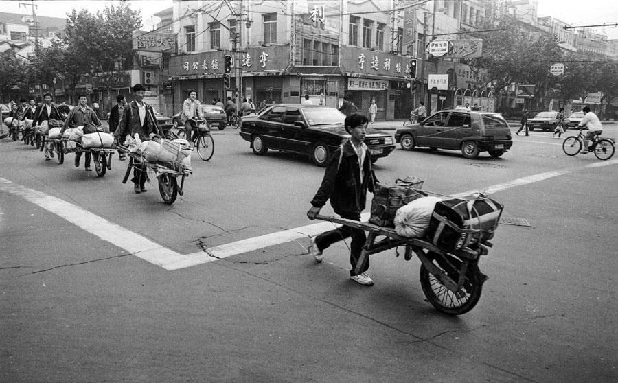 Migrant workers from East China\'s Anhui province walk along Nanjing Road in Shanghai in March, 1983. (Photo by Zhong Nan/For China Daily)
Skimming through this album, one can travel through the panorama of China\'s past four decades, witness how the country transformed from a land of bicycles into a nation of cars, how the gap between rural and urban areas has gradually narrowed, how the development of expressways and high-speed trains has boosted economic and social development, and how an underdeveloped country has become the world\'s second-largest economy.
The more than 300 photographs unfold, in different angles and dimensions, what the country has experienced and achieved in 40 years. Many black and white photos tell the story of a China that has seen the lives of ordinary Chinese undergo fundamental changes.