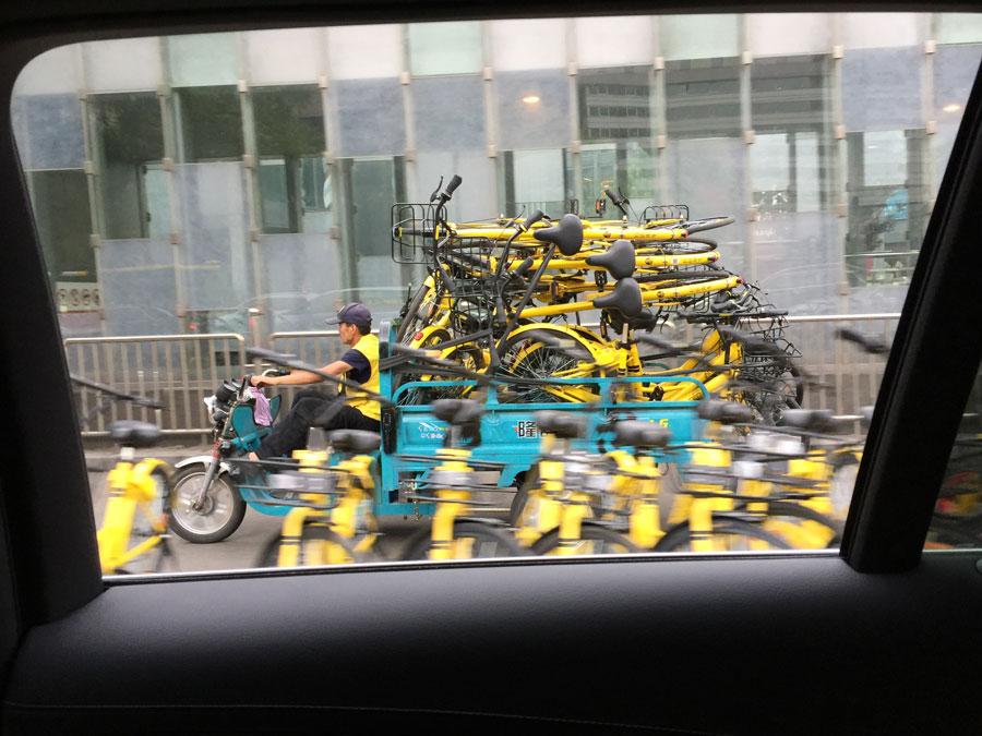A warden transports shared bicycles in Chaoyang district, Beijing, on April 26, 2017. (Photo/China Daily)