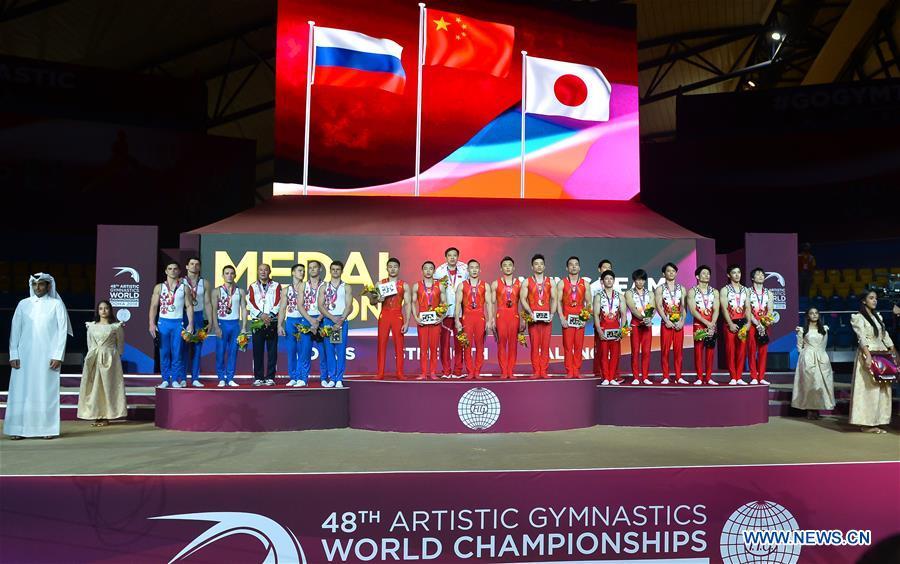 Team China (C), Team Russia (L) and Team Japan pose on the podium after the Men\'s Team Final at the 2018 FIG Artistic Gymnastics Championships in Doha, capital of Qatar, Oct. 29, 2018. Team China won the gold medal. (Xinhua/Nikku)