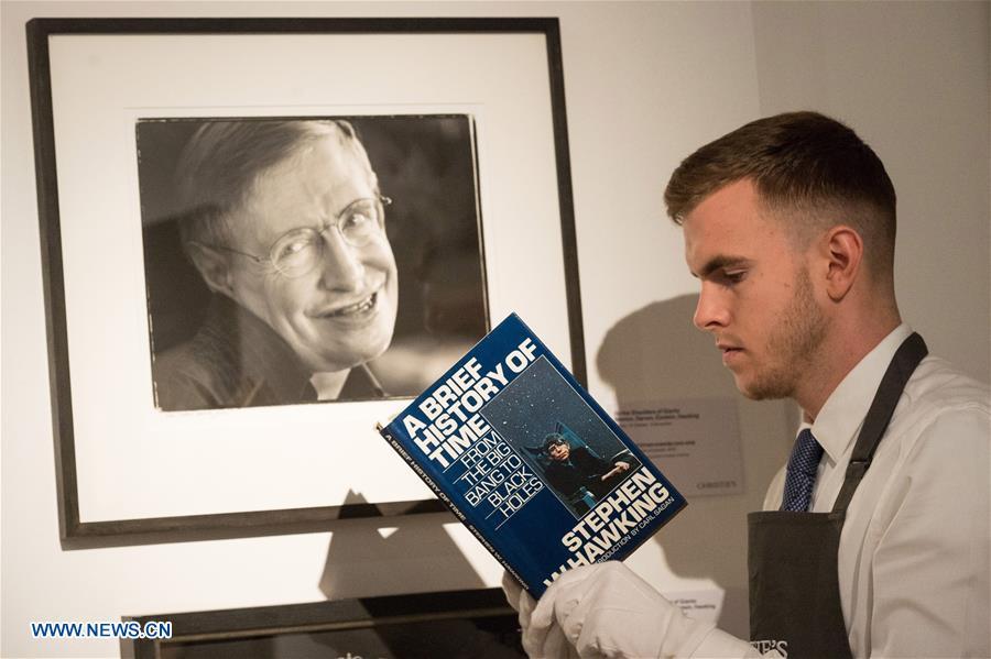 A staff member of auctioneer Christie\'s holds a book titled \