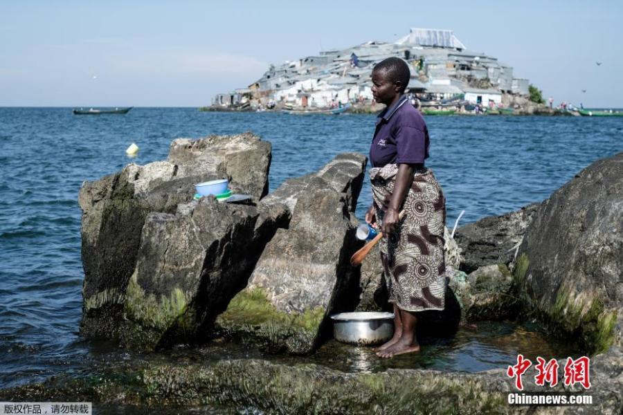 A woman cleans her items on Usingo island next to Migingo island on October 5, 2018 which is densely populated by residents fishing mainly for Nile perch in Lake Victoria on the border of Uganda and Kenya. A rounded rocky outcrop covered in metallic shacks, Migingo Island rises out of the waters of Lake Victoria like an iron-plated turtle. The densely-populated island is barely a quarter of a hectare large, its residents crammed into a hodge-podge of corrugated-iron homes, with seemingly little but a few bars, brothels and a tiny port to boast of. (Photo/Agencies)
