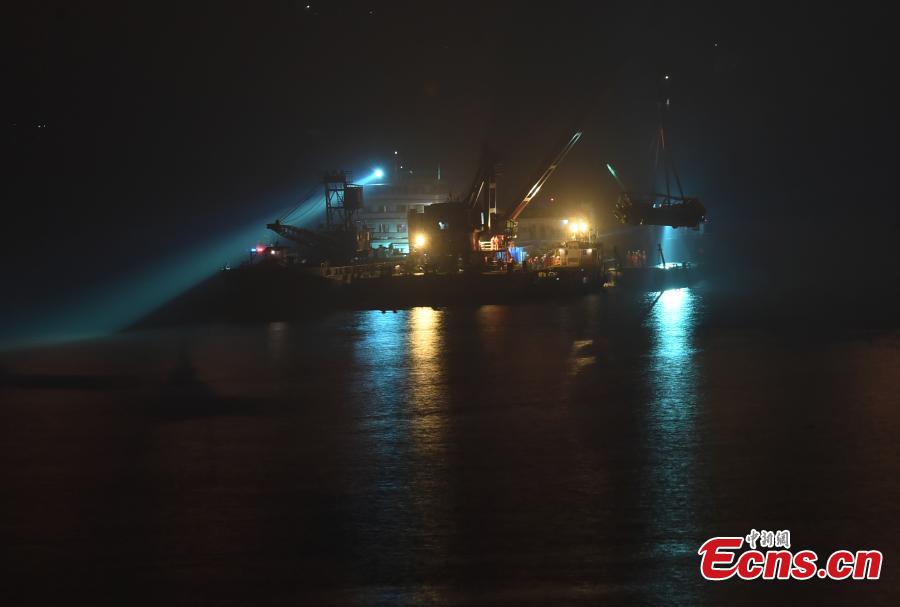 Rescuers on Wednesday night salvaged the wreck of a bus that plunged into the Yangtze River in Chongqing Municipality leaving at least nine people dead. The bus was pulled out of water by a floating crane at about 11:30 p.m.. Rescuers are expected to enter the bus to search for bodies of victims. The bus veered onto the wrong side of the road and collided into an oncoming car before breaking through road fencing and falling off a bridge in Chongqing\'s Wanzhou District on Sunday.(Photo: China News Service/ Chen Chao)