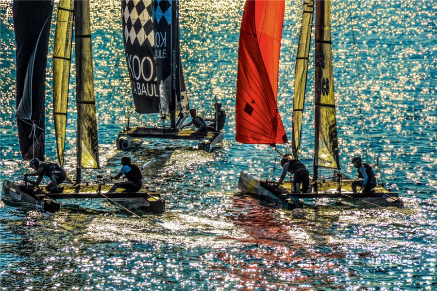 Sailors are involved in a fierce competition on the sea, which looks like a starry sky as it reflects sunlight. (Photo by Yan shengkui/for chinadaily.com.cn)