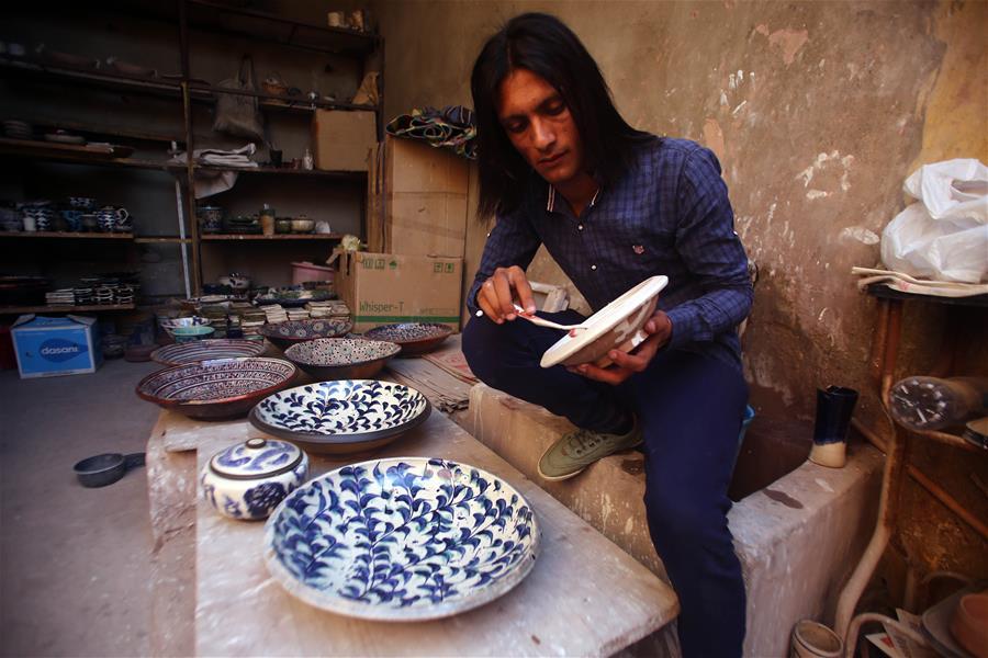 An artist works during the eighth annual Tunis Pottery and Handcrafts Festival in Tunis village, Fayoum province, south of Cairo, capital of Egypt, on Nov. 1, 2018. Crowds of local and foreign visitors have been walking around the little pottery and art shops of Tunis village during the eighth annual Tunis Pottery and Handcrafts Festival. The three-day festival, which kicked off on Nov. 1, showcases unique artworks of pottery and several other handcrafts including wood and granite carving, basket making, handmade carpets, needlework, clay objects and hammered copper. (Xinhua/Ahmed Gomaa)