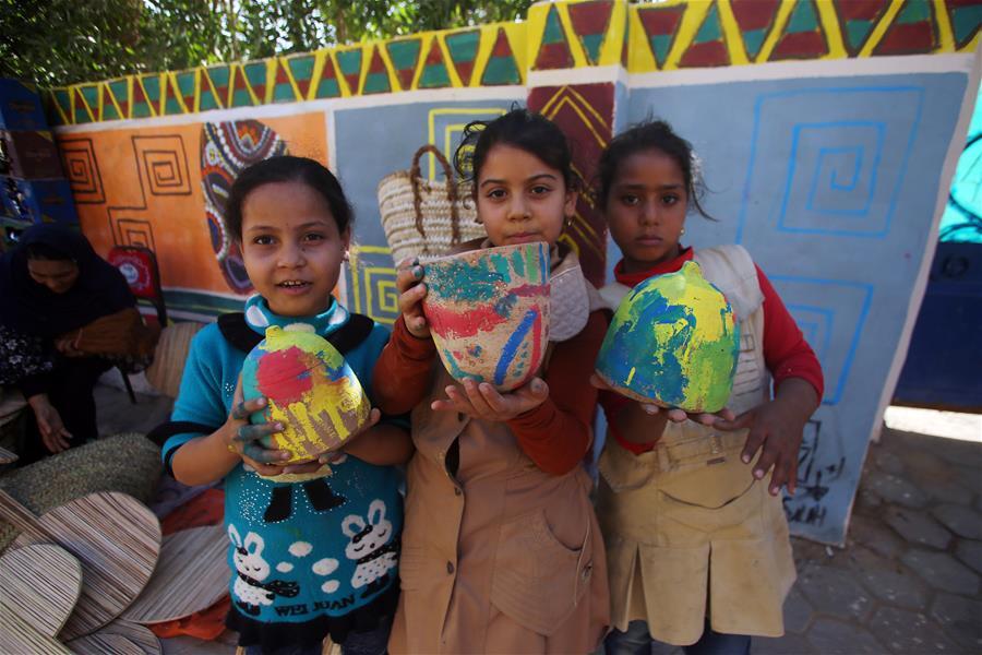 Children show pottery artworks during the eighth annual Tunis Pottery and Handcrafts Festival in Tunis village, Fayoum province, south of Cairo, capital of Egypt, on Nov. 1, 2018. Crowds of local and foreign visitors have been walking around the little pottery and art shops of Tunis village during the eighth annual Tunis Pottery and Handcrafts Festival. The three-day festival, which kicked off on Nov. 1, showcases unique artworks of pottery and several other handcrafts including wood and granite carving, basket making, handmade carpets, needlework, clay objects and hammered copper. (Xinhua/Ahmed Gomaa)