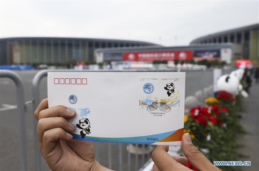 A journalist presents the first day cover with stamps released to commemorate the China International Import Expo (CIIE) at the National Exhibition and Convention Center in Shanghai, east China, Nov. 5, 2018.(Xinhua/Lan Hongguang)
