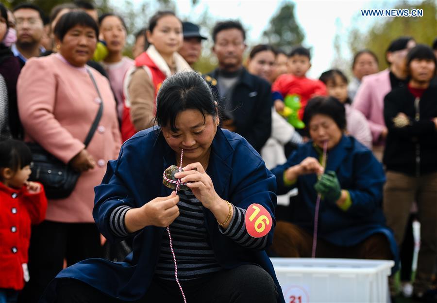 People take part in a crab binding contest in Sihong County, east China\'s Jiangsu Province, Nov. 3, 2018. A total of 100 contestants participated in the event on Saturday. The winner bound 30 crabs within 3 minutes and 59 seconds. (Xinhua/Li Xiang)