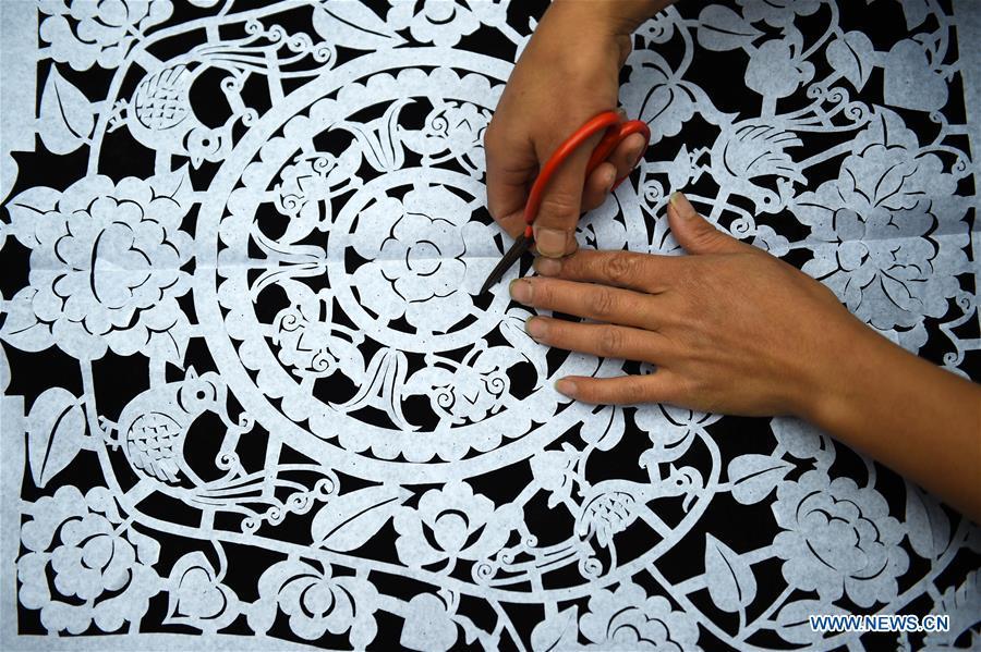 Yang Xinghe designs embroidery patterns at Xinjiang Village in Taijiang County of Qiandongnan Miao and Dong Autonomous Prefecture, southwest China\'s Guizhou Province, on Nov. 4, 2018. Born with hearing loss, Yang Xinghe, 28, is a female of the Miao ethnic group, who are engaged in Miao embroidery at the village. She learned embroidery from her mother when she was only a child, and has been a locally well-known master now. (Xinhua/Liu Kaifu)