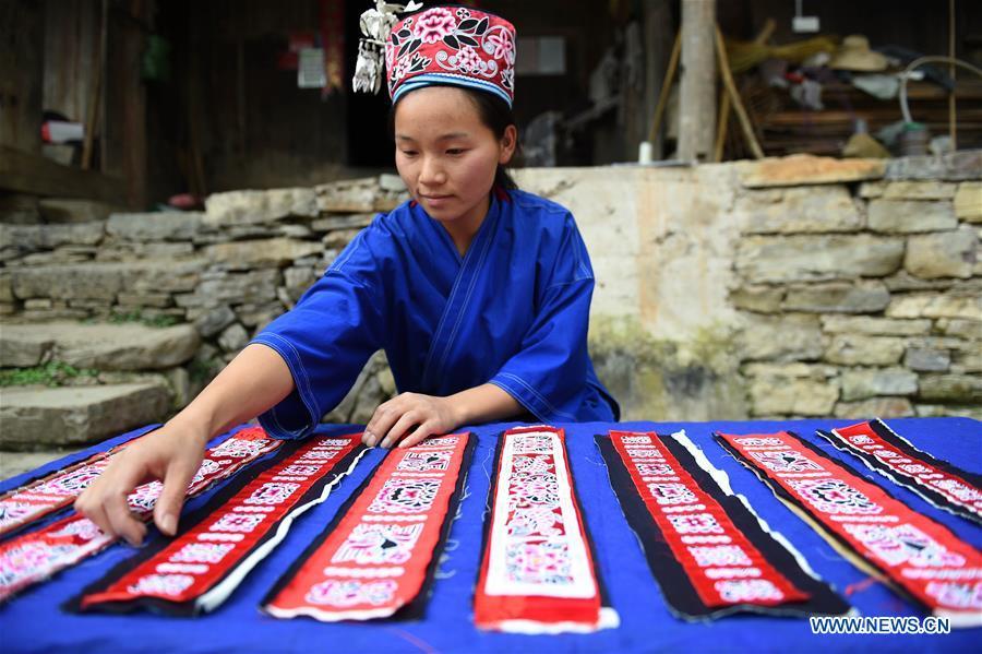 Yang Xinghe classifies embroidered decorations for Miao costumes at Xinjiang Village in Taijiang County of Qiandongnan Miao and Dong Autonomous Prefecture, southwest China\'s Guizhou Province, on Nov. 4, 2018. Born with hearing loss, Yang Xinghe, 28, is a female of the Miao ethnic group, who are engaged in Miao embroidery at the village. She learned embroidery from her mother when she was only a child, and has been a locally well-known master now. (Xinhua/Liu Kaifu)