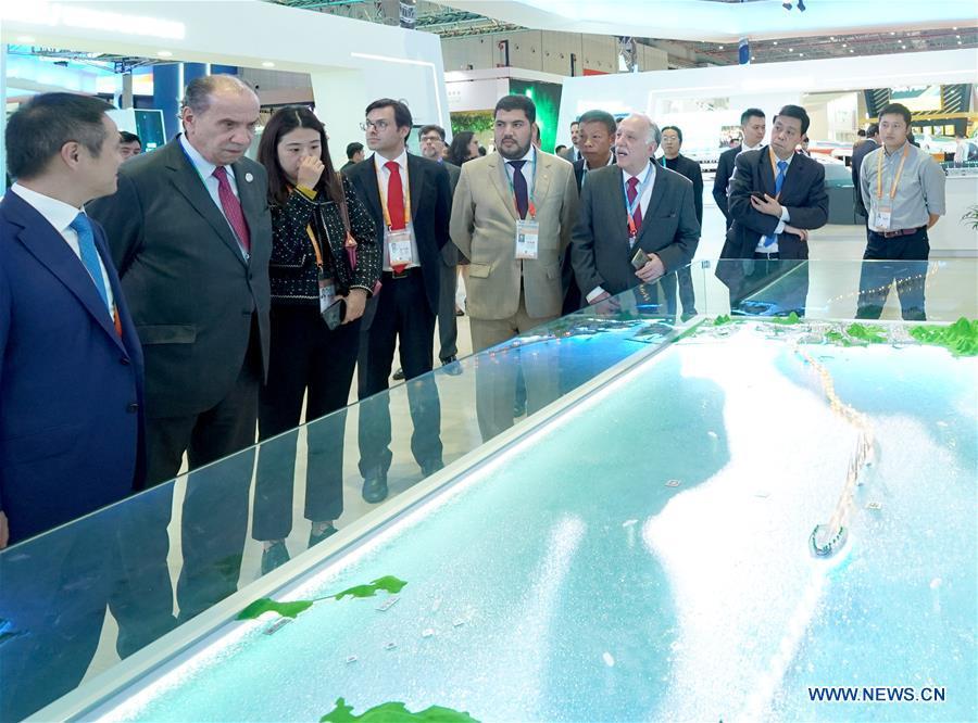 Brazilian government delegation view a model of the Hong Kong-Zhuhai-Macao bridge at the China Pavilion during the first China International Import Expo (CIIE) in Shanghai, east China, Nov. 5, 2018. A total of 82 countries and three international organizations showcased their achievements in economic and trade development as well as competitive products at 71 booths in the Country Pavilion for Trade and Investment at the CIIE.(Xinhua/Chen Jianli)