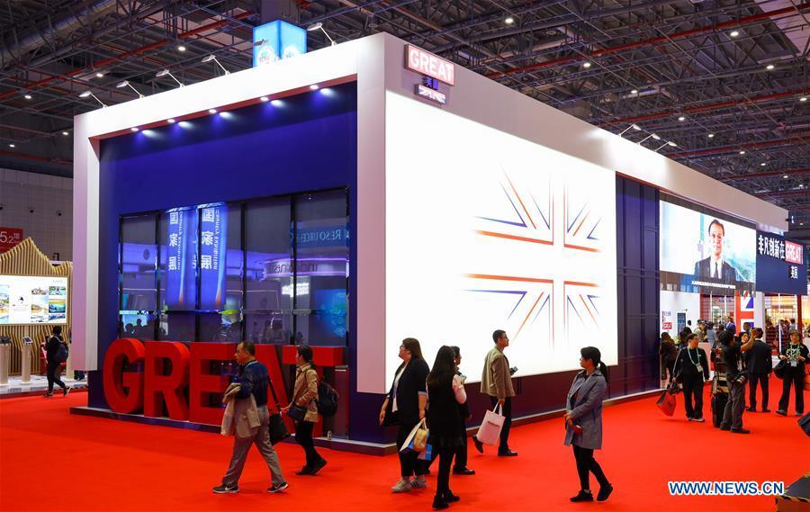 People walk past the United Kingdom pavilion during the first China International Import Expo (CIIE) in Shanghai, east China, Nov. 5, 2018. A total of 82 countries and three international organizations showcased their achievements in economic and trade development as well as competitive products at 71 booths in the Country Pavilion for Trade and Investment at the CIIE. (Xinhua/Liu Dawei)