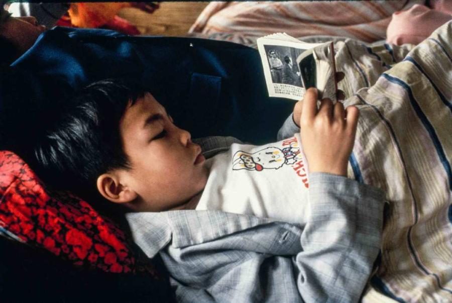 A boy reading a storybook on the boat from Guangzhou, South China\'s Guangdong province to Wuzhou, South China\'s Guangxi Zhuang autonomous region.  (Photo by Jamie Fouss/provided to chinadaily.com.cn)