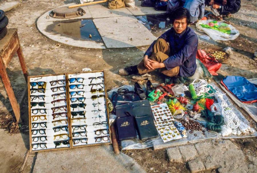 A man selling toys and sunglasses on the street in Guilin, South China\'s Guangxi Zhuang autonomous region.  (Photo by Jamie Fouss/provided to chinadaily.com.cn)