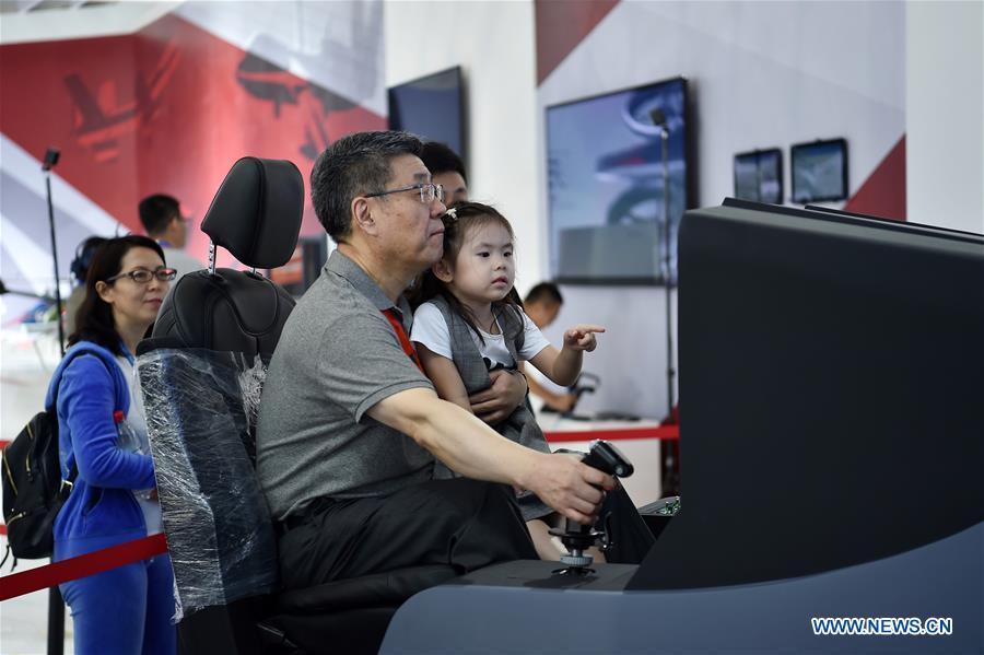 Citizens experience a flying simulator at the exhibition area of the upcoming China International Aviation and Aerospace Exhibition in Zhuhai, south China\'s Guangdong Province, Nov. 5, 2018. The exhibition is scheduled to be held on Nov. 6-11. (Xinhua/Liang Xu)
