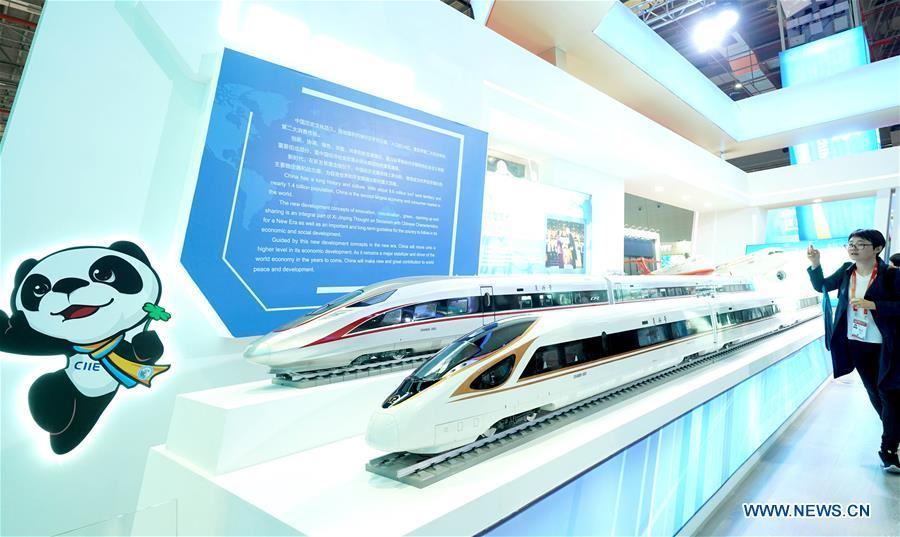 A journalist shoots models of China\'s Fuxing bullet train at the China Pavilion during the first China International Import Expo (CIIE) in Shanghai, east China, Nov. 5, 2018. A total of 82 countries and three international organizations showcased their achievements in economic and trade development as well as competitive products at 71 booths in the Country Pavilion for Trade and Investment at the CIIE. (Xinhua/Chen Jianli)