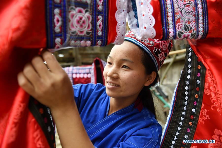 Yang Xinghe embroiders Miao costumes at Xinjiang Village in Taijiang County of Qiandongnan Miao and Dong Autonomous Prefecture, southwest China\'s Guizhou Province, on Nov. 4, 2018. Born with hearing loss, Yang Xinghe, 28, is a female of the Miao ethnic group, who are engaged in Miao embroidery at the village. She learned embroidery from her mother when she was only a child, and has been a locally well-known master now.(Xinhua/Liu Kaifu)