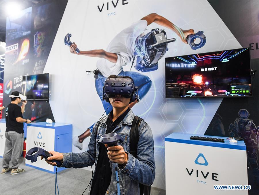 A visitor tries a virtual reality (VR) device at the Light of Internet Expo of the fifth World Internet Conference in Wuzhen Township of Tongxiang, east China\'s Zhejiang Province, Nov. 6, 2018. Opening here on Tuesday, the exposition focuses on the world\'s most recent internet development trends and cutting-edge technologies, showing the latest internet technologies, achievements, products and applications of more than 430 enterprises and institutions from home and abroad. (Xinhua/Xu Yu)