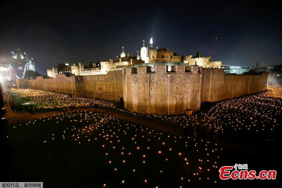 The moat of the Tower of London are seen filled with thousands of lit torches as part of the installation \