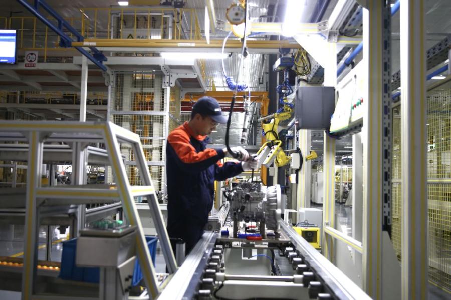 A technician operates a machine at the workshop of Jiaxing Xuanfu Automatic Transmission Co. (Photo/China Daily)