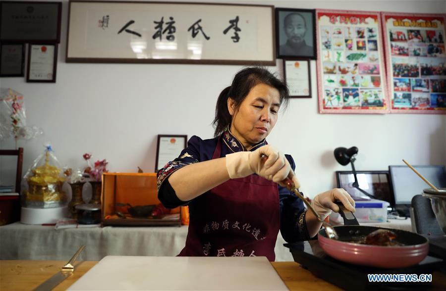 Folk artist Li Fengyan prepares syrup to make sugar sculptures in Shenyang, northeast China\'s Liaoning Province, Nov. 6, 2018. The sugar sculpture of the Li family was listed as an intangible cultural heritage by the city of Shenyang. As the fifth-generation inheritor of her family\'s craft, Li Fengyan is making efforts to pass down the set of sugar-sculpting know-hows to her apprentices. (Xinhua/Yang Qing)