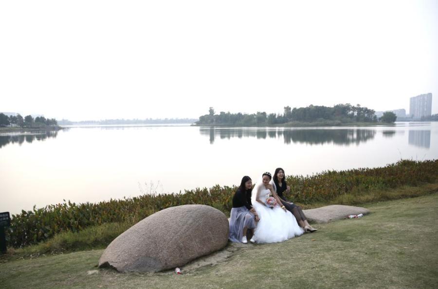 A bride and her friends pose for pictures at Fenghuang Lake in Tongxiang.  (Photo/China Daily)