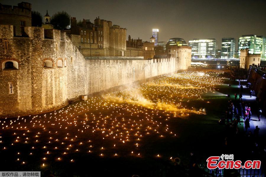The moat of the Tower of London are seen filled with thousands of lit torches as part of the installation \
