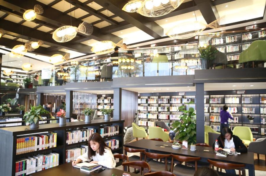 Residents of Tongxiang enjoy reading at its first self-served Bohong Library by the Fenghuang Lake. (Photo/China Daily)