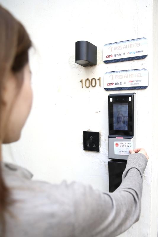 A guest checks in to the Binzhi AI Hotel that uses facial recognition technology and ID card reading system in place of a conventional reception desk. (Photo/China Daily)