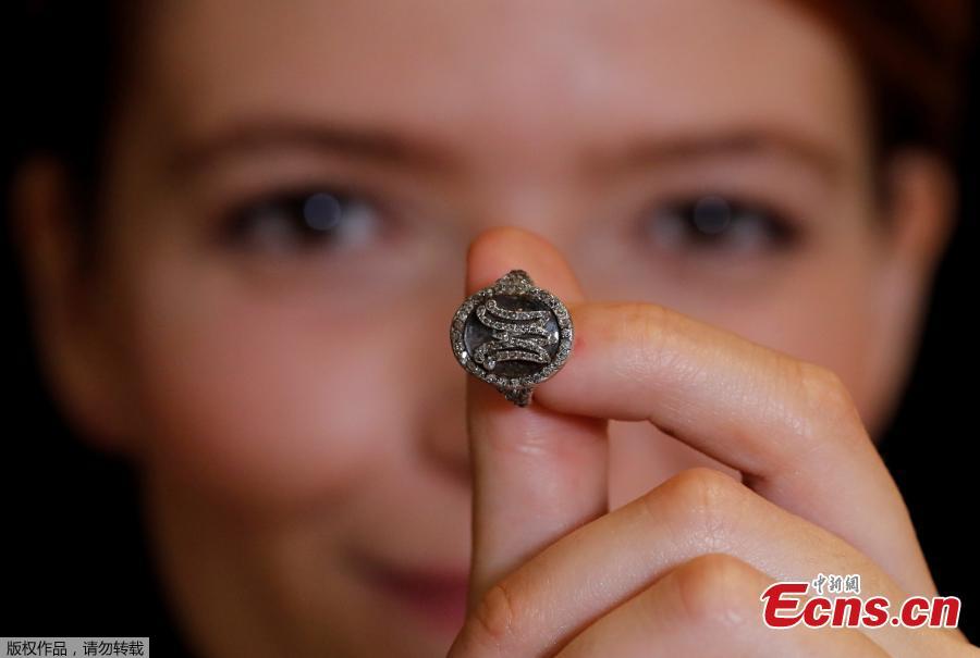 A model holds a diamond ring bearing the initials MA for Marie Antoinette and containing a lock of her hair during a press preview ahead of the upcoming auction \