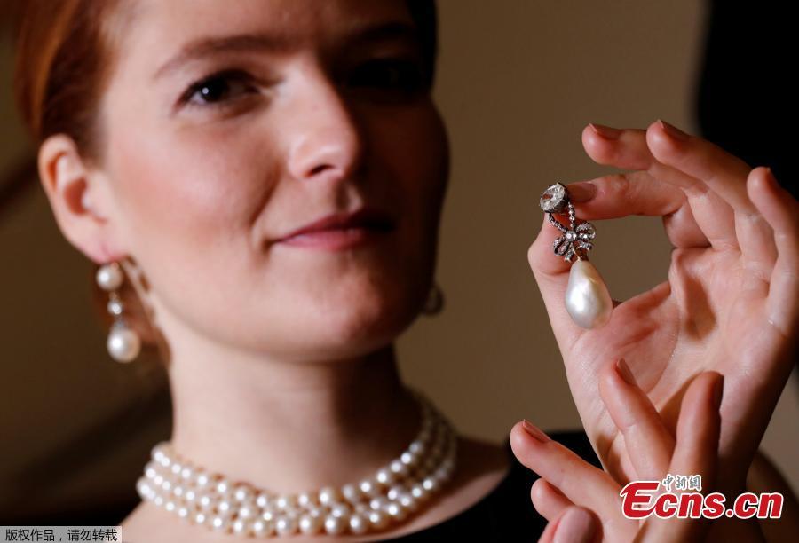 A model holds a natural pearl and diamond pendant once owned by Marie Antoinette together with wearing a pair of natural drops and a necklace featuring 119 natural pearls during a press preview ahead of the upcoming auction \