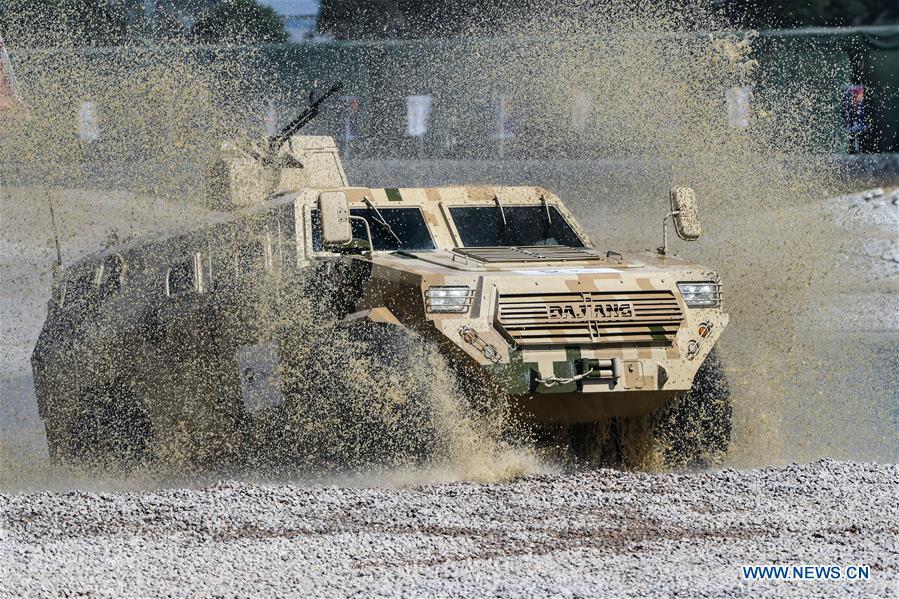 An armored vehicle wades through a puddle during a dynamic display of ground military equipments at the 12th China International Aviation and Aerospace Exhibition (Airshow China) in Zhuhai, south China\'s Guangdong Province, on Nov. 7, 2018. (Xinhua/Yang Guang)