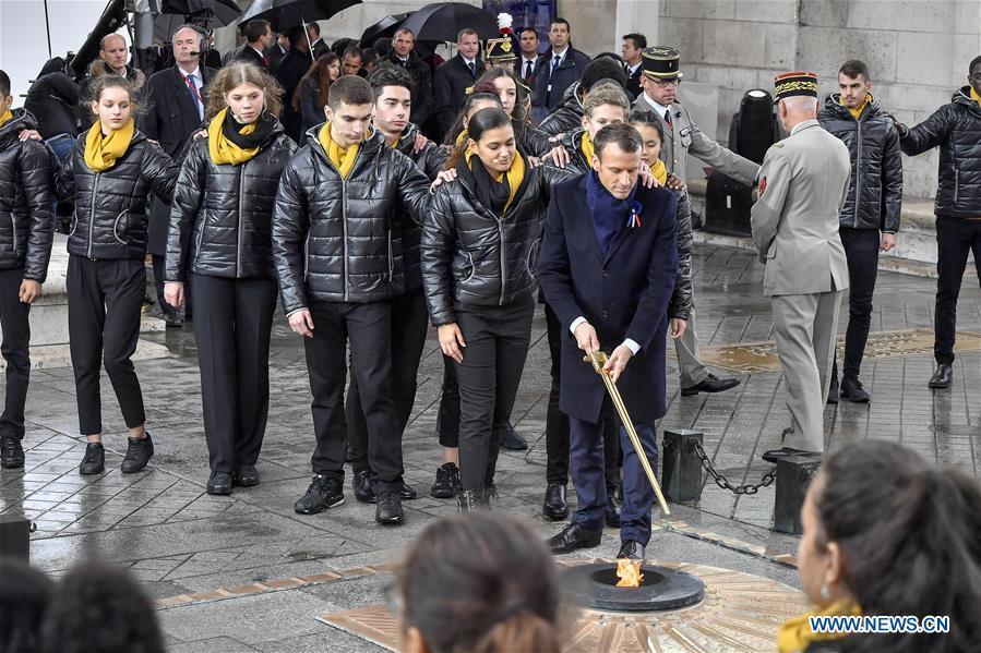 French President Emmanuel Macron revives a fire near the Tomb of the Unknown Soldier during a ceremony to mark the centenary of the Armistice of the First World War in Paris, France, Nov. 11, 2018. (Xinhua/Chen Yichen)