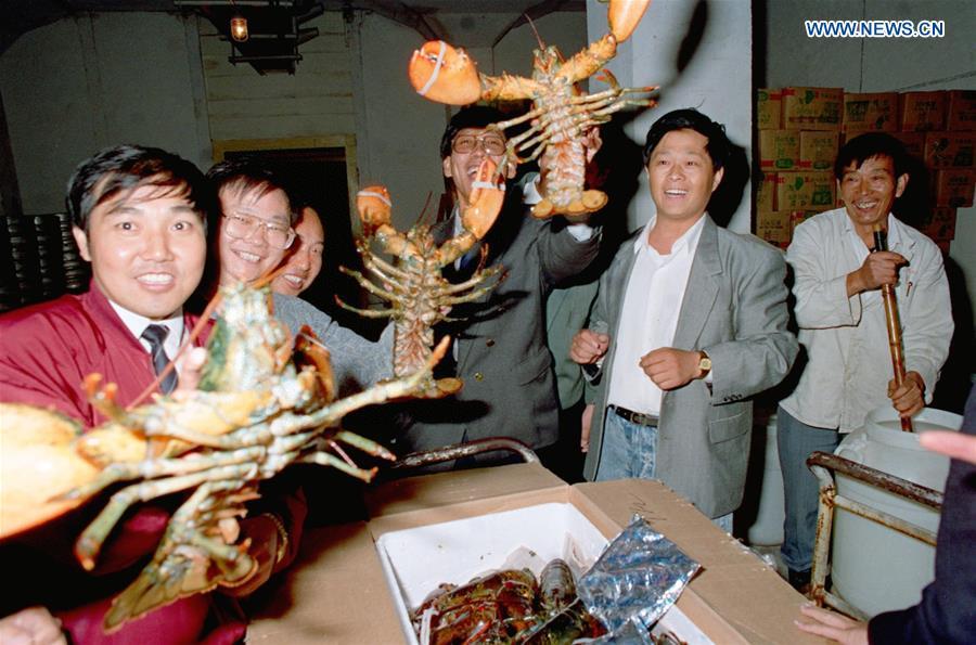 People show lobsters imported from Canada after they were flown in by a 20-hour journey to Shanghai, east China, Oct. 8, 1992. (Xinhua/Zhang Ming)