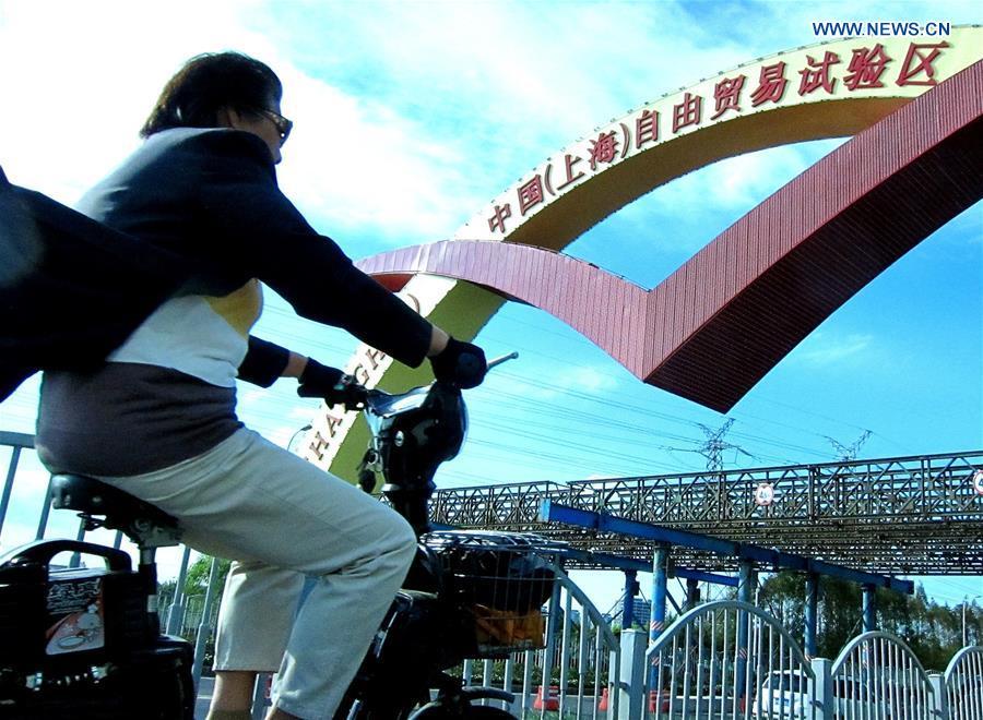 A cyclist drives at the entrance to the China (Shanghai) Pilot Free Trade Zone in Shanghai, east China, Sept. 26, 2013. (Xinhua/Chen Fei)