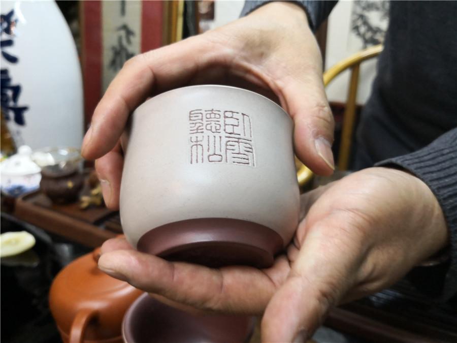 Zhao Qiushi presents a microscopic carving.  (Photo/chinadaily.com.cn)
