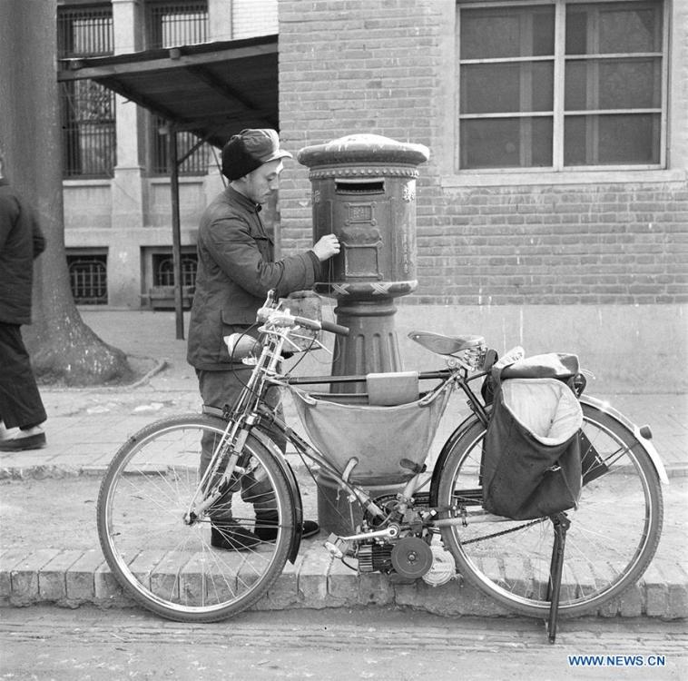 File photo taken on Feb. 19, 1959 shows a postman collecting mails from a mailbox in Beijing, capital of China. The postman used a modified bicycle equipped with engine to ride faster, a move made by local authority to accelerate the delivery of letters. More than four decades of sound economic growth from 1978, the starting year of the reform and opening-up policy, has fundamentally lifted life quality of 1.3 billion Chinese, who are now able to enjoy the \