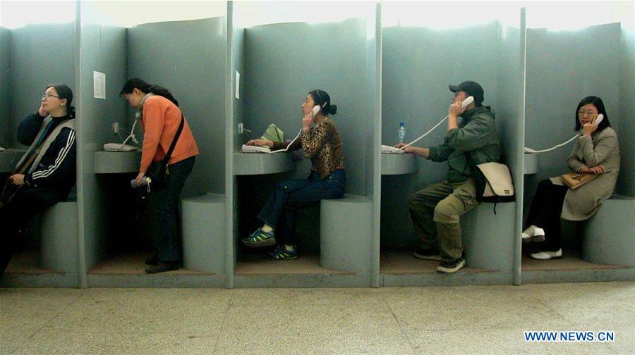 People make long-distance phone calls at a public booth in Yan\'an, northwest China\'s Shaanxi Province, April 23, 2002. More than four decades of sound economic growth from 1978, the starting year of the reform and opening-up policy, has fundamentally lifted life quality of 1.3 billion Chinese, who are now able to enjoy the \